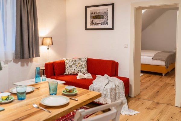 landhaus-apartments-appartement-18-wohnzimmer-sofa-esstisch-gedeckt landhaus-apartments-appartement-18-wohnzimmer-sofa-esstisch-gedeckt